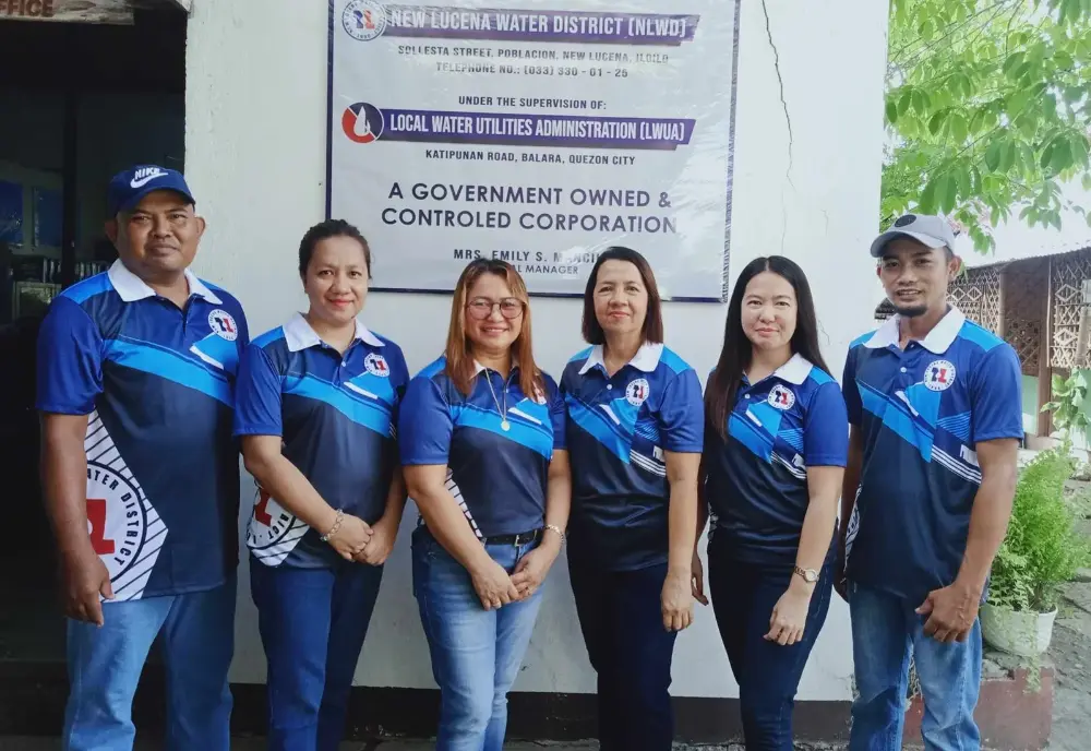 Six NLWD staff in blue district shirts standing outside the office on Sollesta Street
